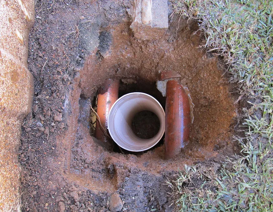 Installed seepage control system showing pipes in excavated hole